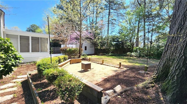 view of yard with an outbuilding, a sunroom, and a patio area