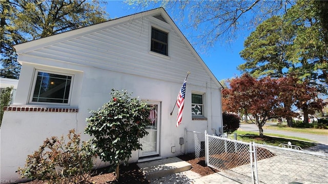 view of front facade featuring stucco siding and fence