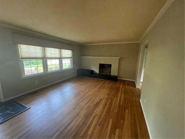 418 Pin Oak Rd, Newport News, VA 23601 - unfurnished living room with baseboards, a fireplace with raised hearth, wood finished floors, and crown molding