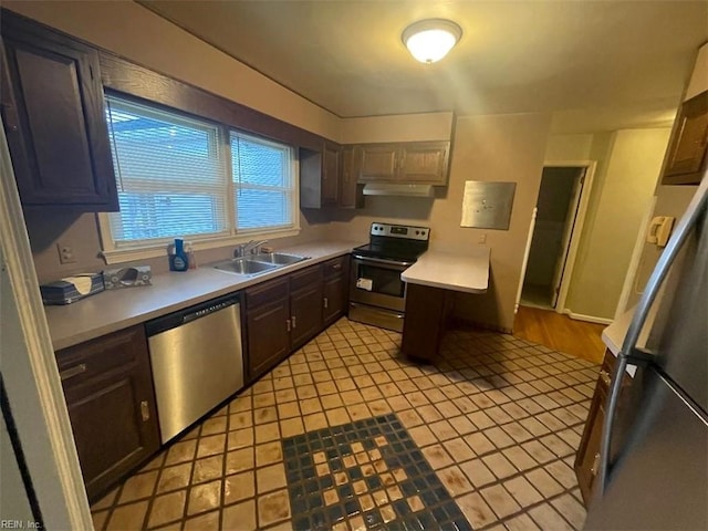 418 Pin Oak Rd, Newport News, VA 23601 - kitchen with light countertops, under cabinet range hood, a sink, light tile patterned flooring, and appliances with stainless steel finishes