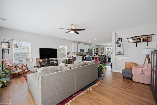 living area featuring visible vents, baseboards, recessed lighting, a ceiling fan, and light wood-type flooring