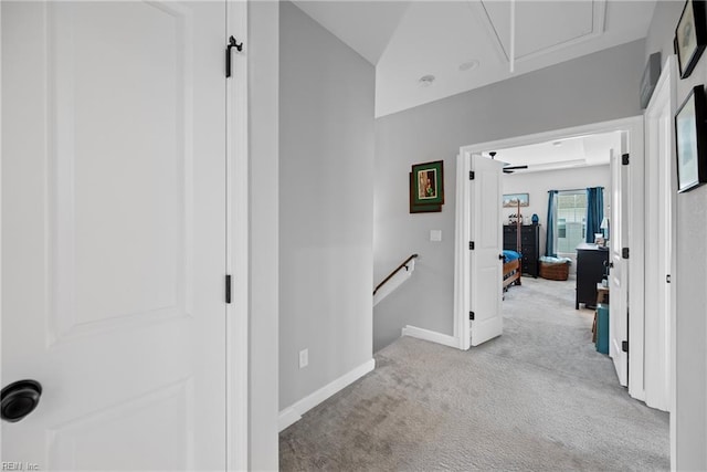 corridor featuring attic access, baseboards, an upstairs landing, and carpet