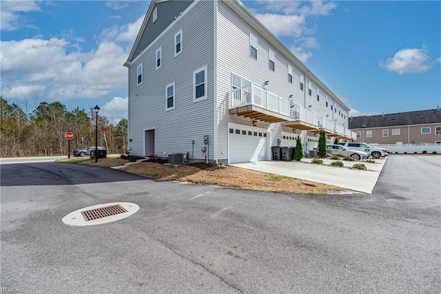 view of side of home featuring driveway and an attached garage