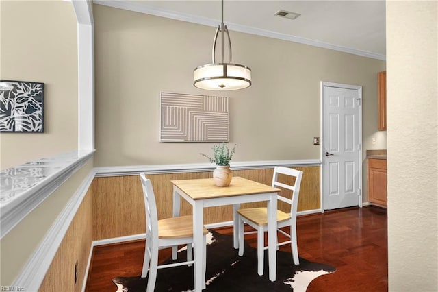 dining room with ornamental molding, visible vents, and dark wood finished floors