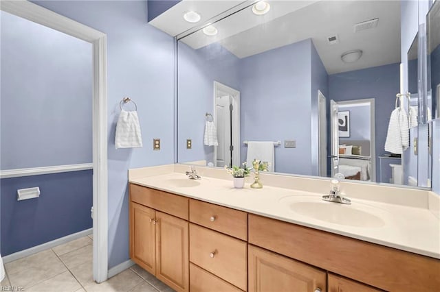 bathroom featuring toilet, tile patterned floors, a sink, and double vanity