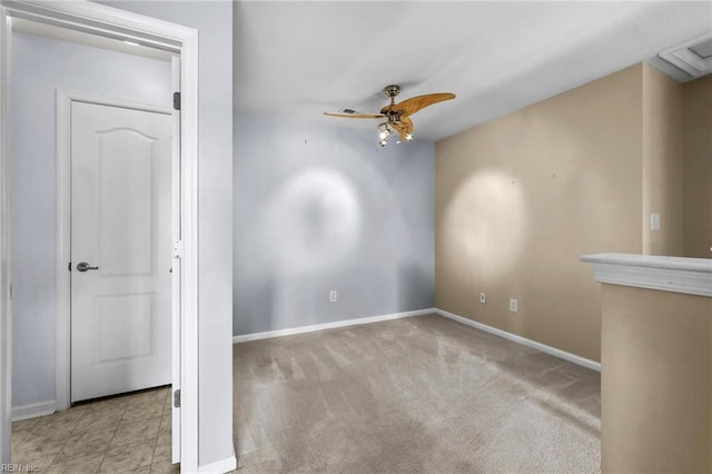 carpeted spare room featuring baseboards and a ceiling fan