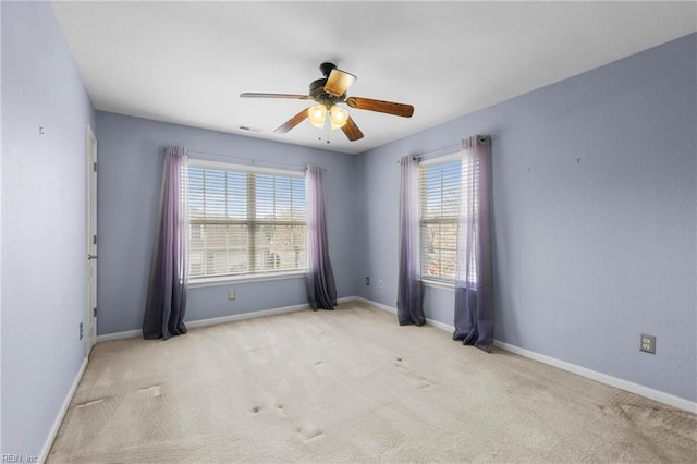 empty room featuring baseboards, carpet flooring, visible vents, and a ceiling fan