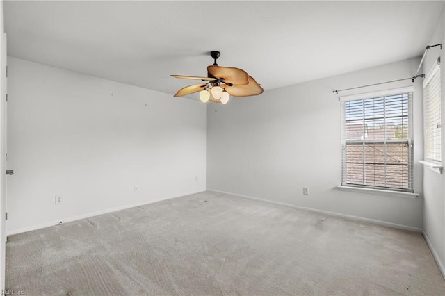 carpeted empty room with baseboards and ceiling fan