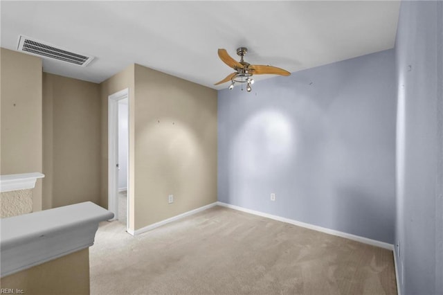 carpeted empty room featuring baseboards, ceiling fan, and visible vents