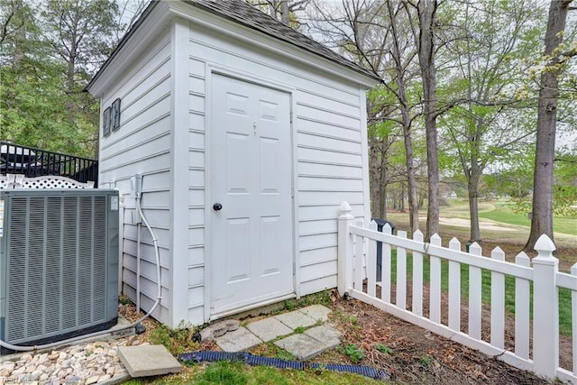 view of shed with cooling unit and fence