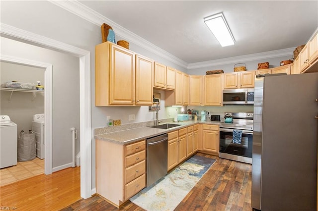 kitchen featuring crown molding, a sink, light brown cabinets, stainless steel appliances, and washer and dryer
