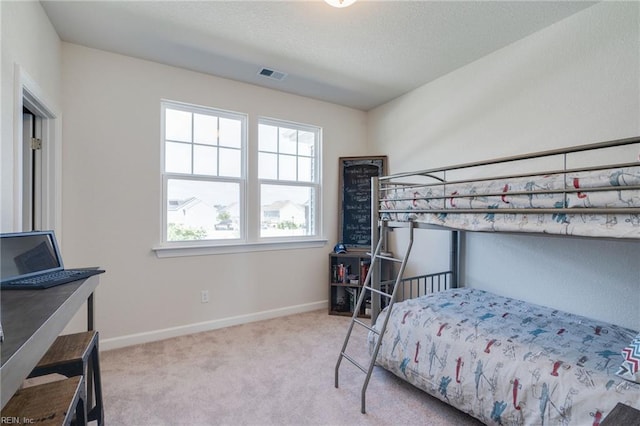 bedroom featuring baseboards, carpet floors, a textured ceiling, and visible vents