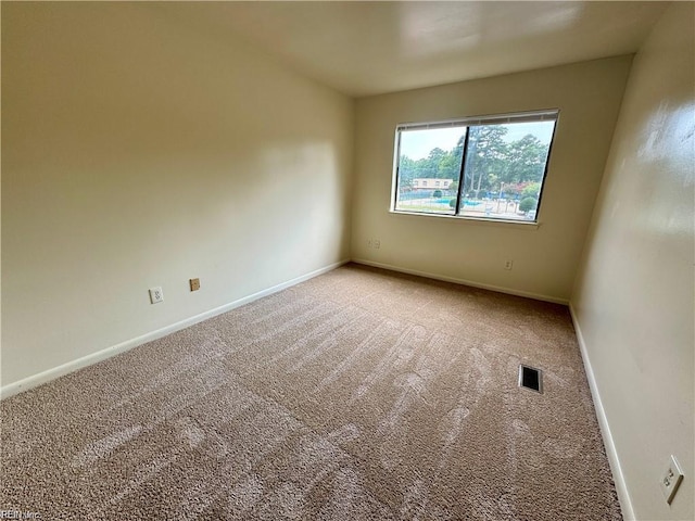 carpeted empty room featuring baseboards and visible vents