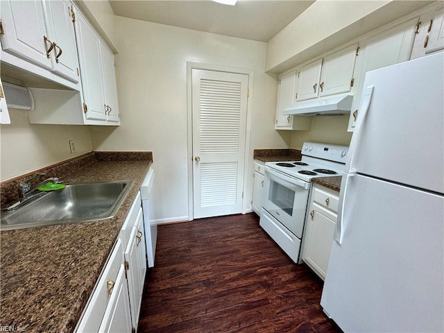 kitchen featuring a sink, dark wood-style floors, under cabinet range hood, white appliances, and dark countertops
