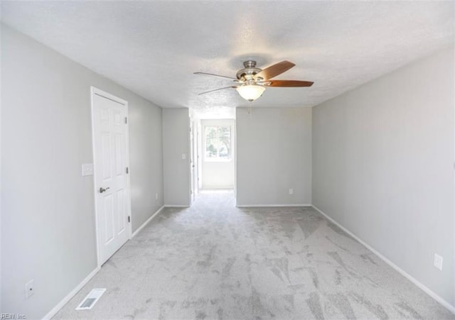 empty room featuring visible vents, baseboards, a ceiling fan, and carpet