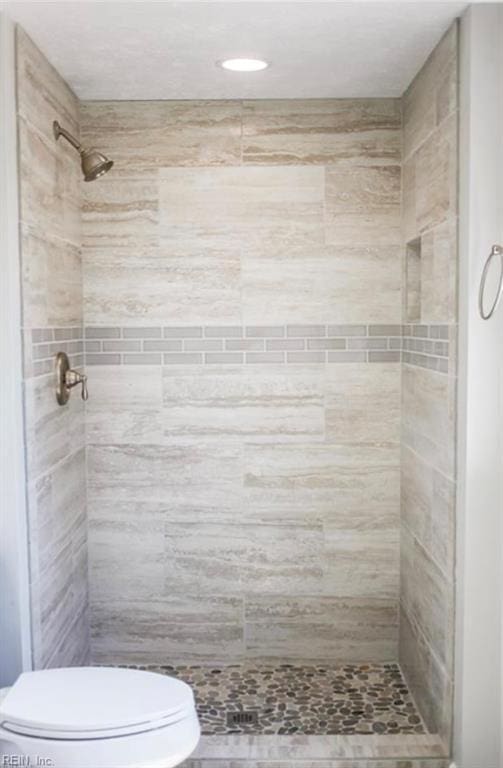 full bath with toilet and a stall shower