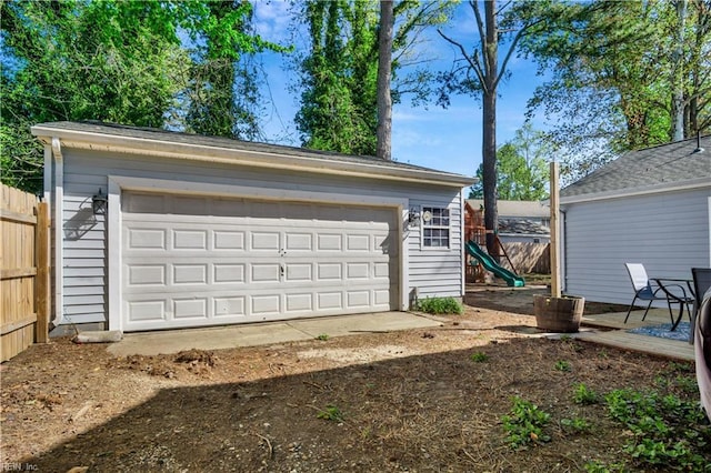 detached garage featuring fence