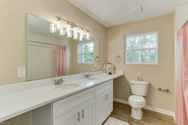 bathroom featuring toilet, wood finished floors, a sink, and baseboards