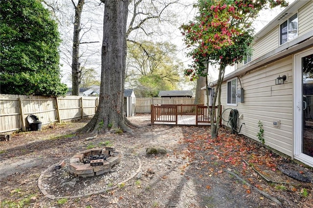 1413 Seward Dr, Hampton, VA 23663 - view of yard featuring an outdoor fire pit, an outbuilding, a deck, a storage shed, and a fenced backyard