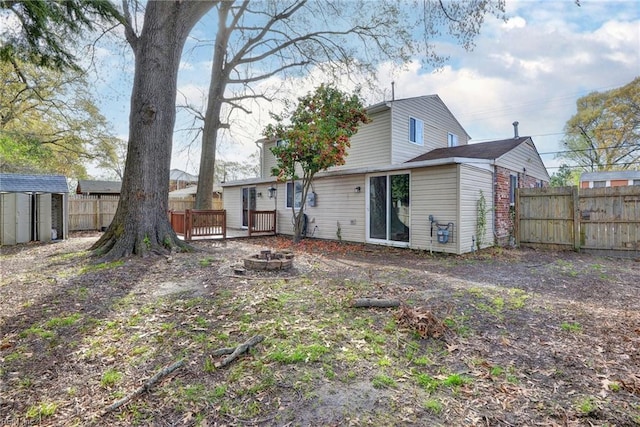 1413 Seward Dr, Hampton, VA 23663 - rear view of property with an outdoor fire pit, an outbuilding, a deck, and fence