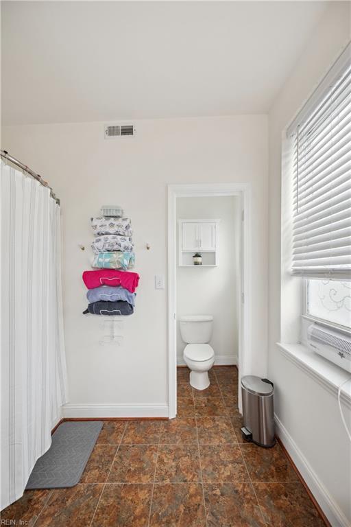 bathroom with plenty of natural light, baseboards, visible vents, and toilet