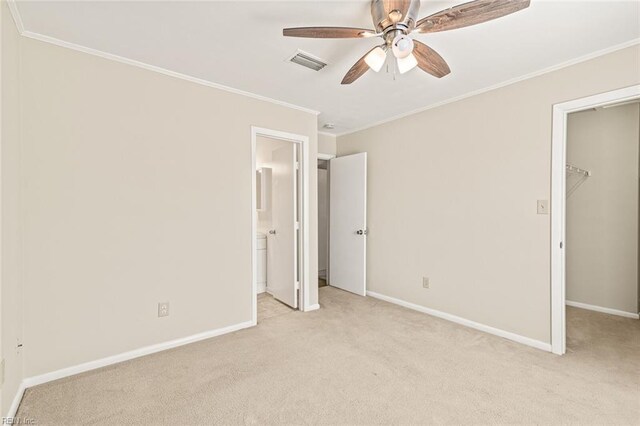 3955 Palomino Dr Unit 201, Newport News, VA 23602 - unfurnished bedroom featuring a walk in closet, ornamental molding, baseboards, visible vents, and light carpet