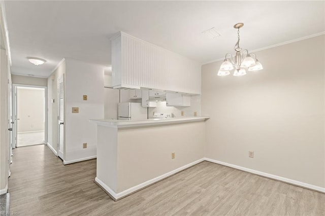 3955 Palomino Dr Unit 201, Newport News, VA 23602 - kitchen featuring light countertops, a peninsula, crown molding, light wood-style floors, and freestanding refrigerator