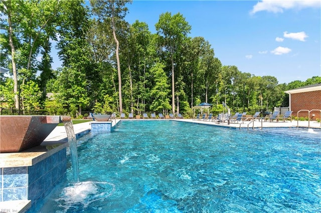 community pool with a patio area and fence