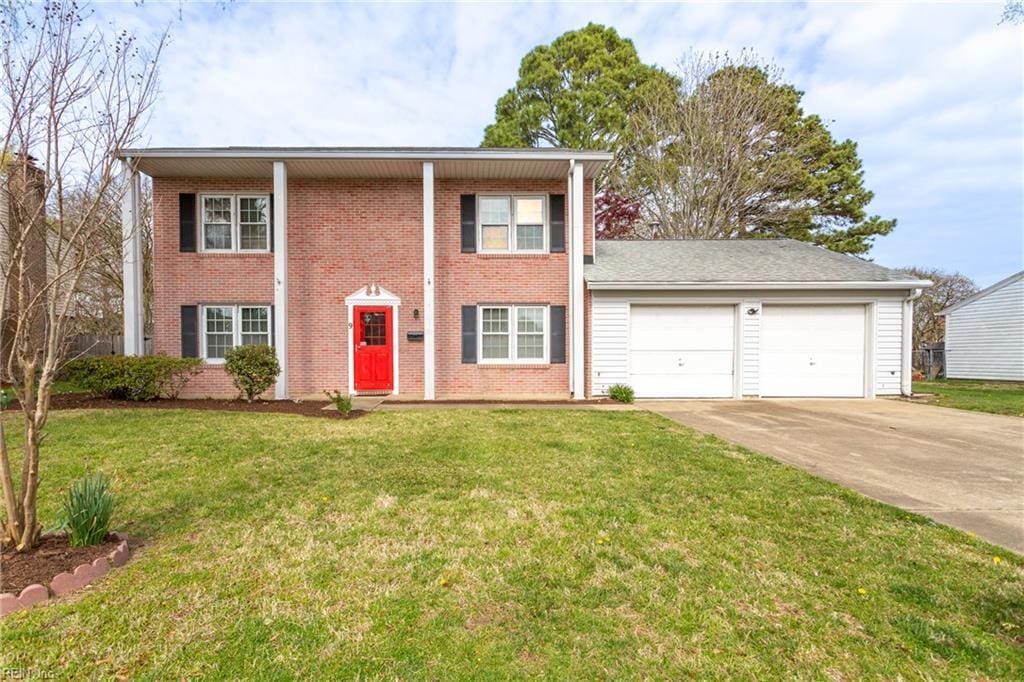 view of front of house with driveway, an attached garage, brick siding, and a front yard