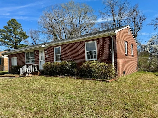 ranch-style house featuring brick siding, a front lawn, and crawl space
