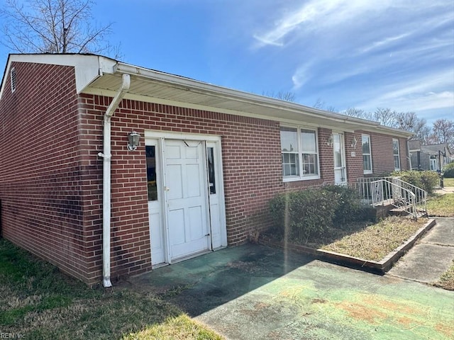 doorway to property featuring brick siding