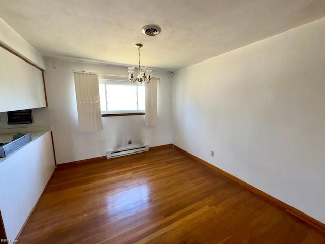 unfurnished dining area with baseboards, a baseboard heating unit, an inviting chandelier, visible vents, and wood finished floors