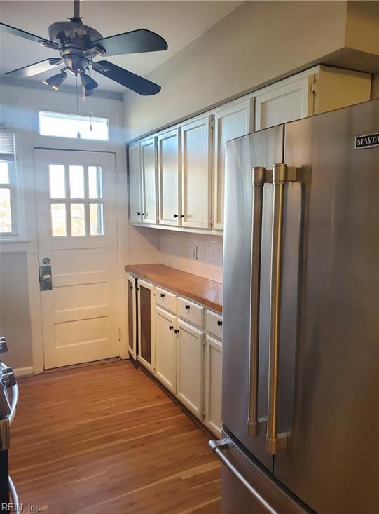 kitchen with light wood-style flooring, white cabinets, ceiling fan, and high end fridge