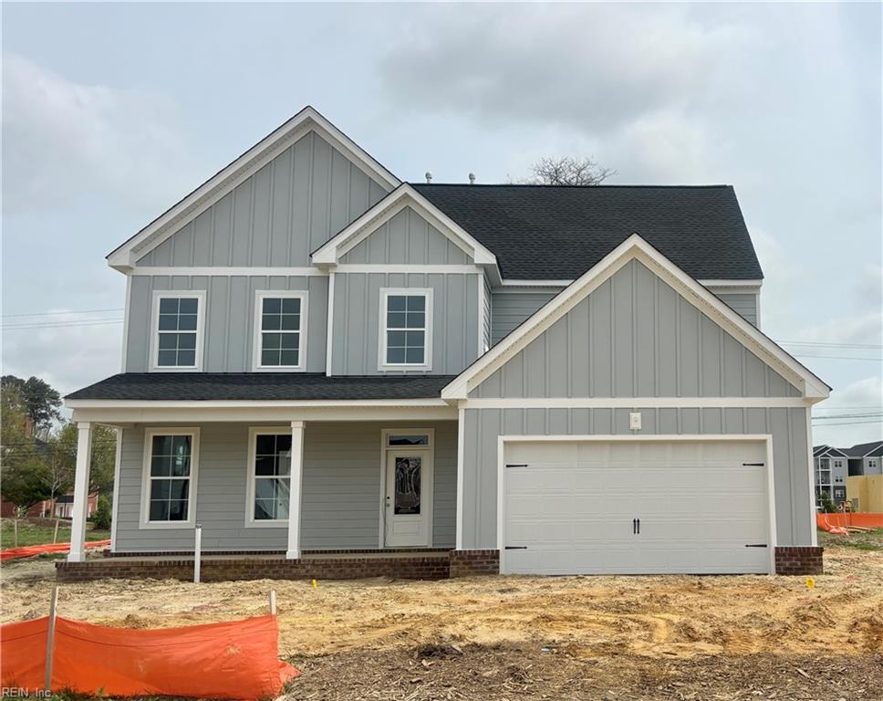 view of front of house with an attached garage, board and batten siding, and a porch