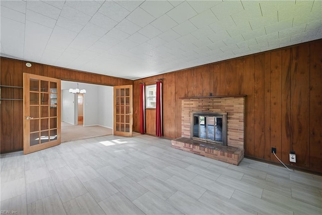 8084 Lynnbrook Dr, Norfolk, VA 23518 - unfurnished living room with wood walls, a fireplace, and a chandelier