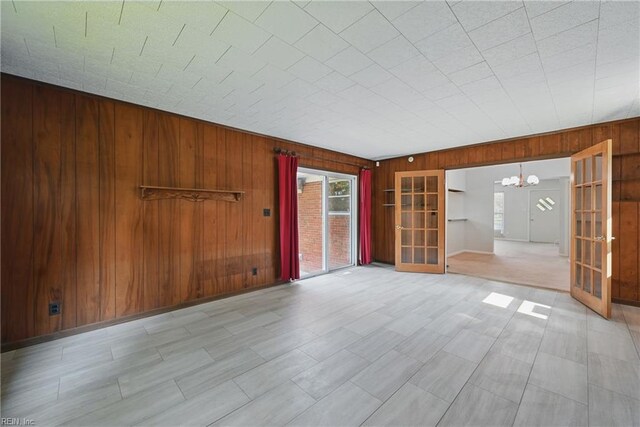 8084 Lynnbrook Dr, Norfolk, VA 23518 - spare room featuring wooden walls, a chandelier, and french doors