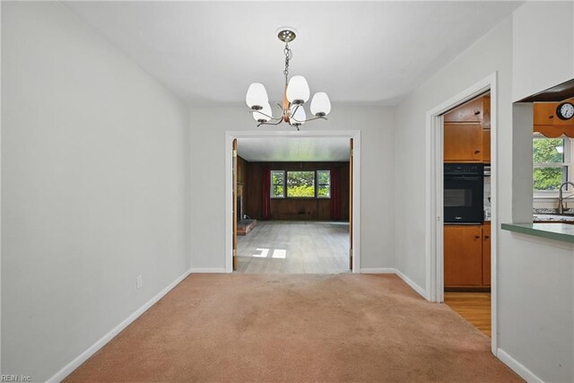 8084 Lynnbrook Dr, Norfolk, VA 23518 - unfurnished dining area with light carpet, a chandelier, baseboards, and a sink
