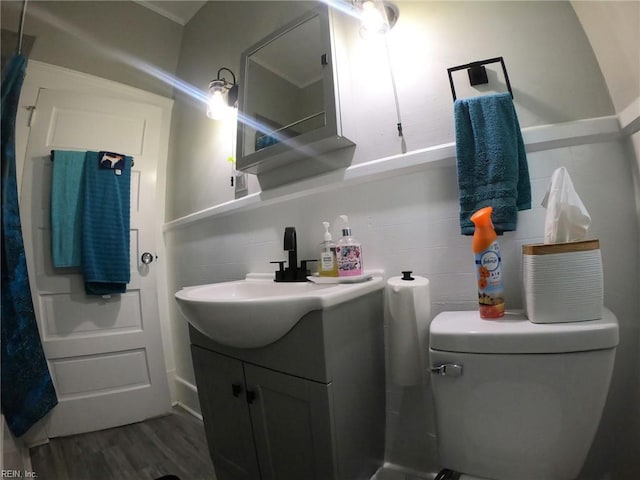 bathroom featuring vanity, toilet, and wood finished floors