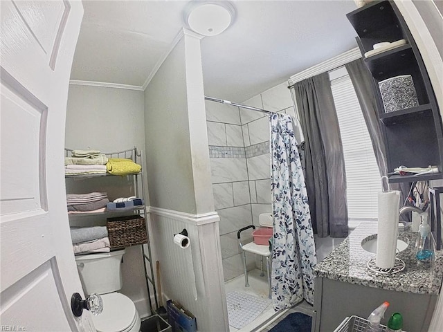bathroom featuring a stall shower, toilet, vanity, and crown molding