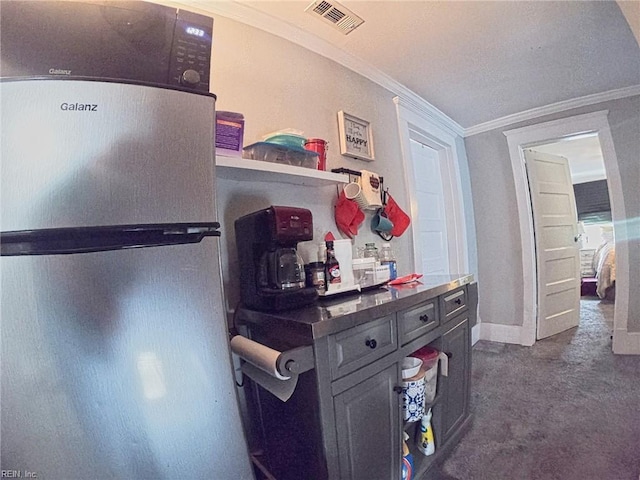 interior space featuring dark carpet, visible vents, baseboards, and ornamental molding