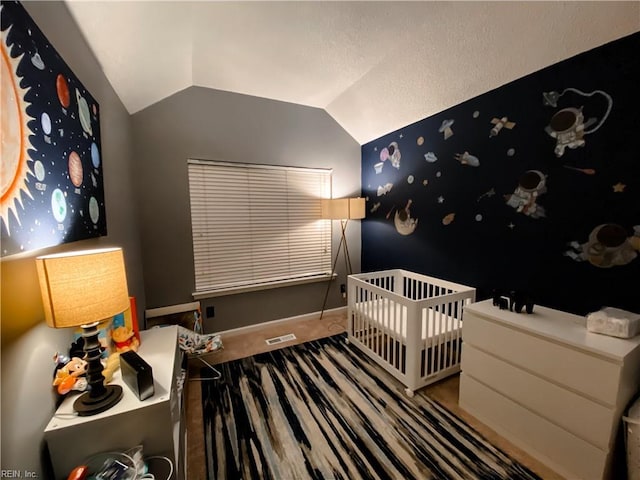bedroom with baseboards, visible vents, vaulted ceiling, and a nursery area