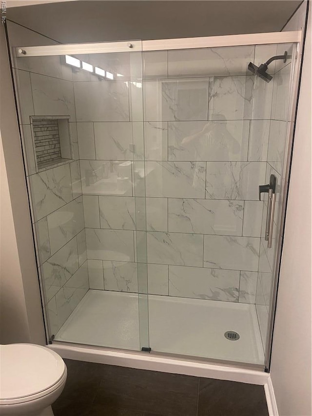 bathroom with a stall shower and toilet