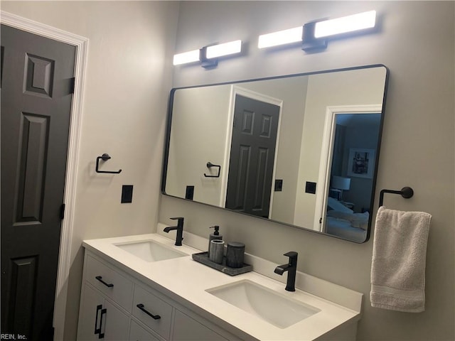 full bath with double vanity, a sink, and ensuite bathroom