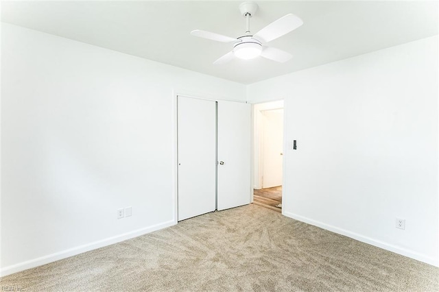 unfurnished bedroom featuring a ceiling fan, a closet, carpet, and baseboards