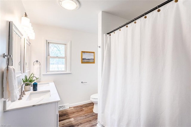 full bath featuring visible vents, baseboards, toilet, wood finished floors, and vanity