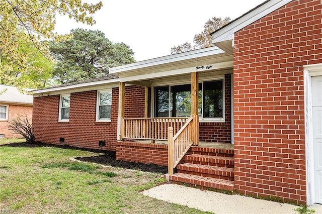 doorway to property featuring crawl space, covered porch, brick siding, a garage, and a lawn