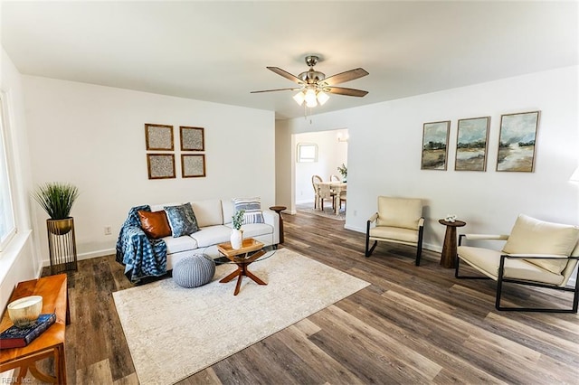 living room featuring baseboards, wood finished floors, and a ceiling fan