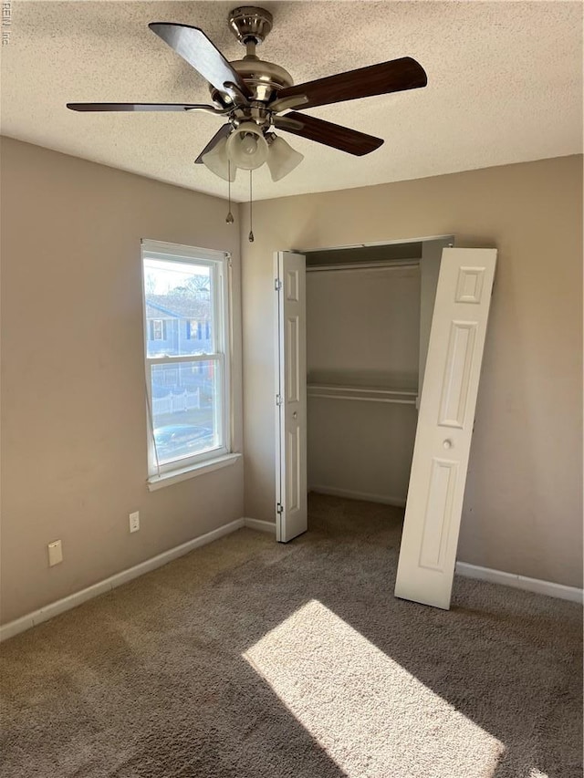 unfurnished bedroom with baseboards, a closet, carpet flooring, and a textured ceiling