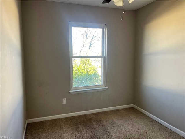 carpeted empty room with a ceiling fan and baseboards