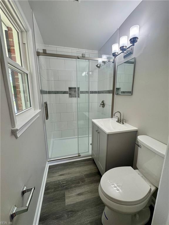 97 Waterview Dr, Newport News, VA 23608 - bathroom featuring vanity, toilet, a stall shower, a notable chandelier, and wood finished floors